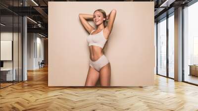 Young woman in underwear on beige background. Fitness, diet, skin and body care Wall mural